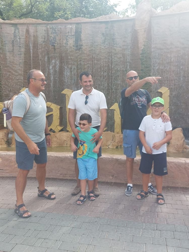 Papà e bambini in gita davanti a una fontana