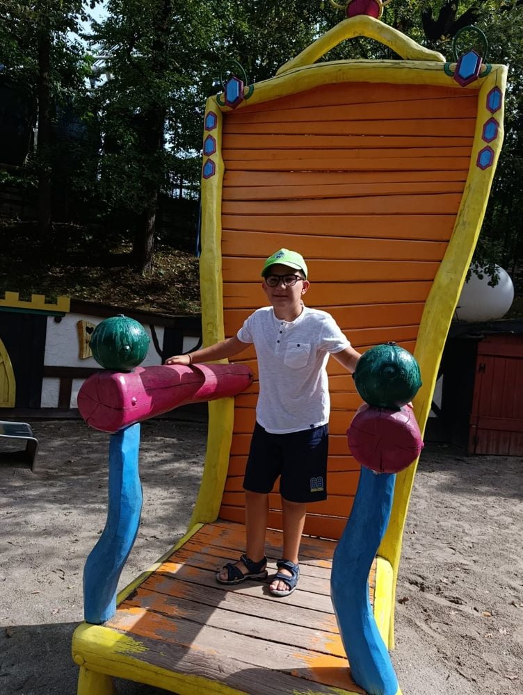 Bambino su un grande trono colorato