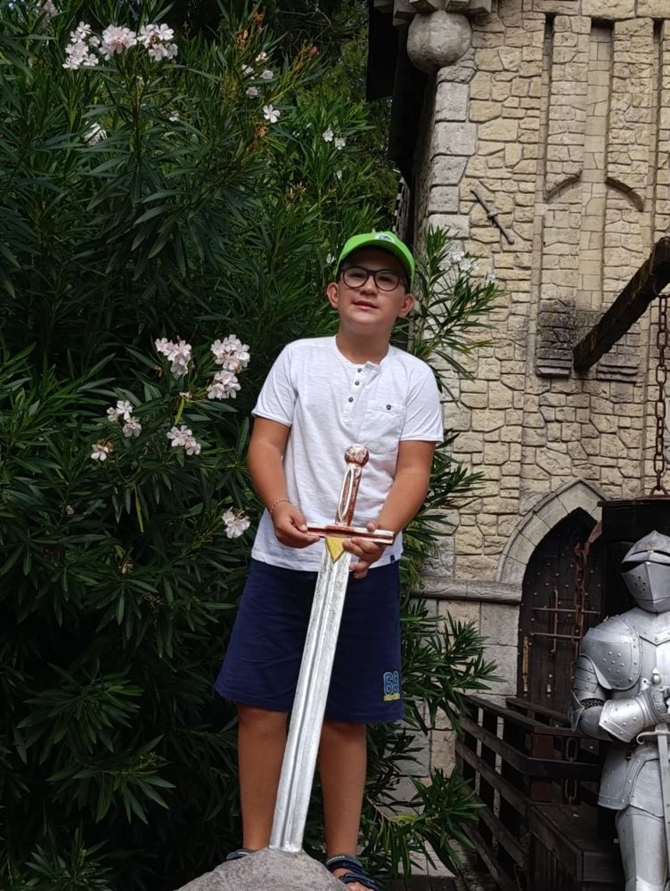 Bambino con una spada davanti a un castello